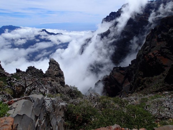 Wolken die als een waterval de berg op waaien