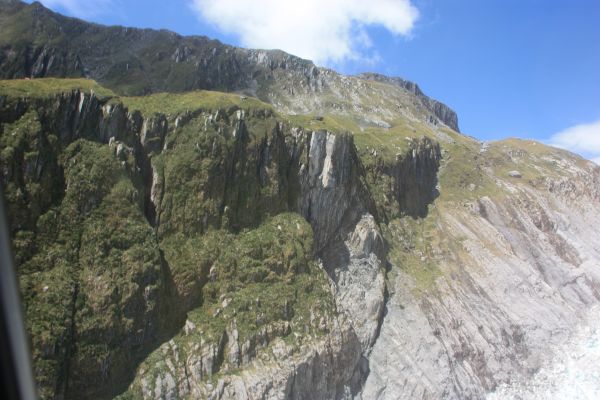 foto vanuit helikopter van bergen naast gletsjer